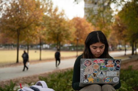 A Georgia Tech student reads outdoors 