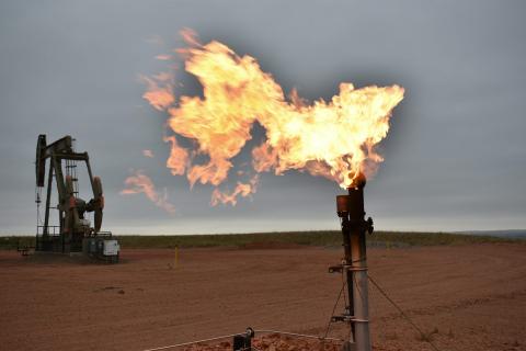 A flare burns natural gas at an oil well on Aug. 26, 2021, in Watford City, N.D. 