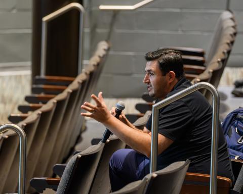 Person speaking into microphone inside theater