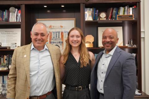 Georgia Tech President Ángel Cabrera, 2026 Truman Scholar Taylor Witte, and Provost Raheem Beyah stand in front of memorabilia-filled bookshelves.